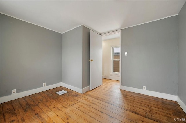 spare room featuring crown molding and light hardwood / wood-style flooring