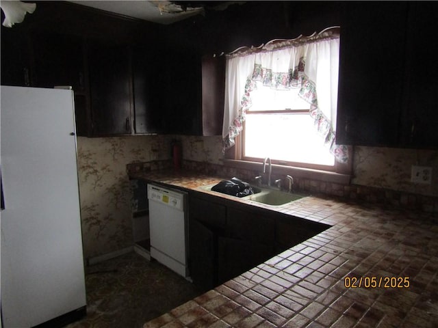 kitchen featuring white appliances, tile countertops, and sink