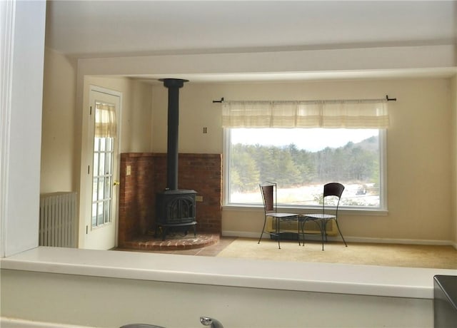 interior space featuring radiator, a wood stove, and baseboards