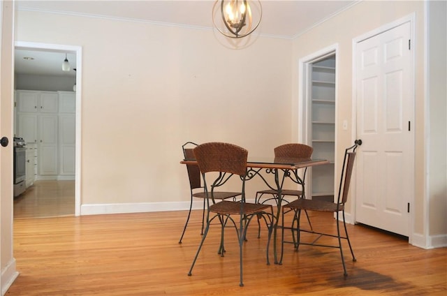 dining room featuring a chandelier, ornamental molding, wood finished floors, and baseboards