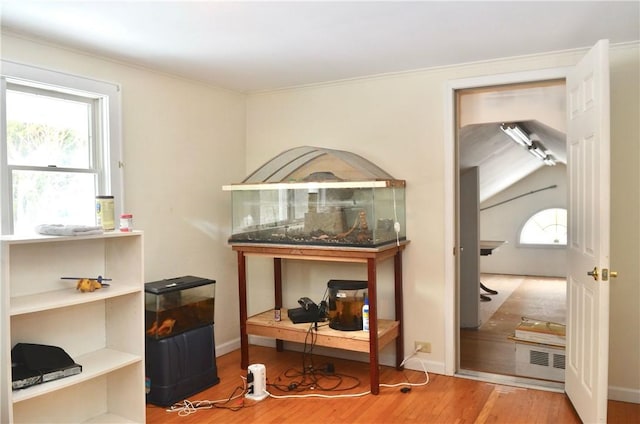 interior details featuring crown molding, visible vents, baseboards, and wood finished floors