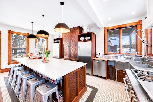 kitchen featuring pendant lighting, stainless steel appliances, a breakfast bar, and a kitchen island