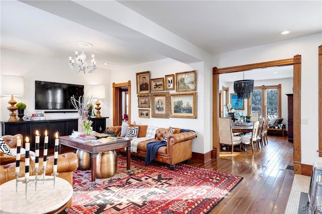 living room with an inviting chandelier and dark wood-type flooring