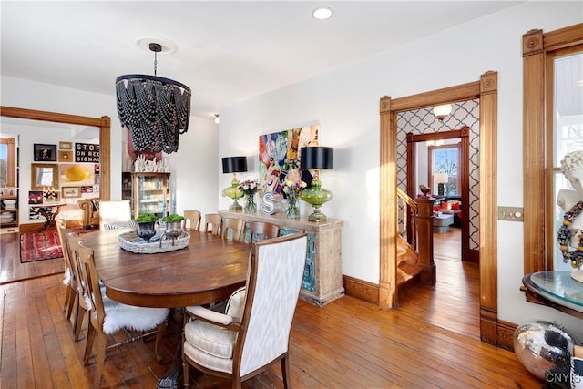 dining space with hardwood / wood-style flooring and a chandelier