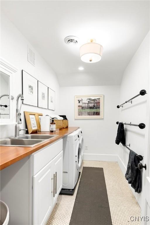 laundry area with cabinets, sink, and washing machine and dryer