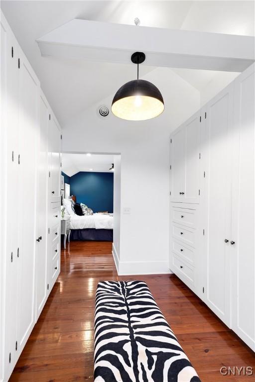 hall with lofted ceiling with beams and dark hardwood / wood-style floors