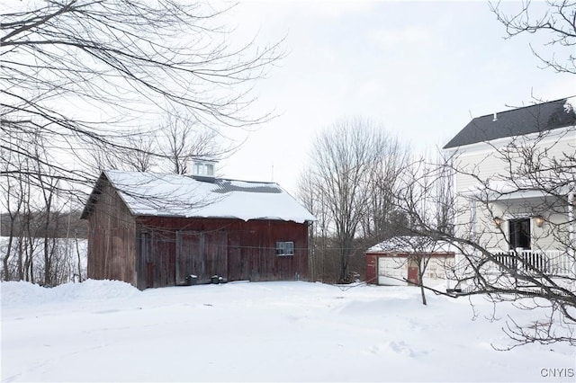 view of snowy exterior featuring an outdoor structure