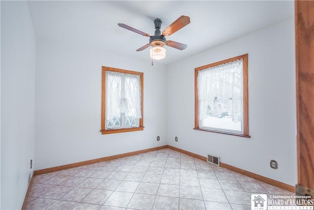 unfurnished room with light tile patterned floors and ceiling fan