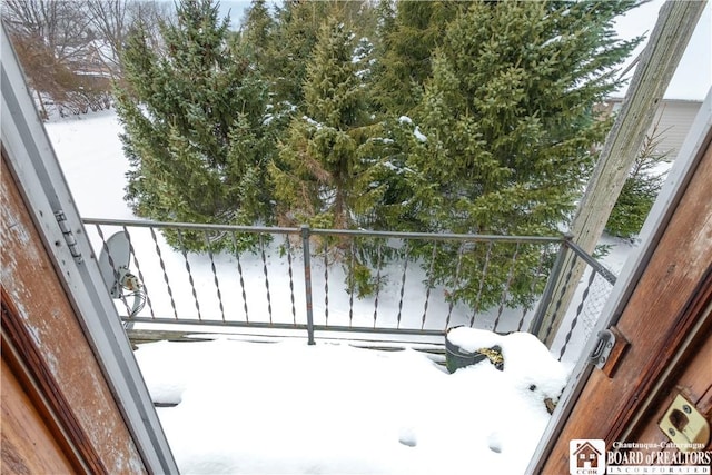 view of snow covered back of property