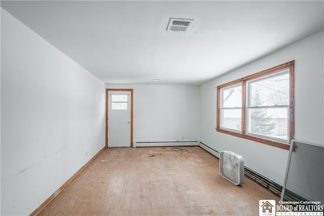 spare room featuring light wood-type flooring and baseboard heating