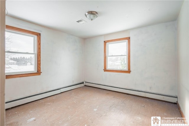 unfurnished room with a baseboard heating unit