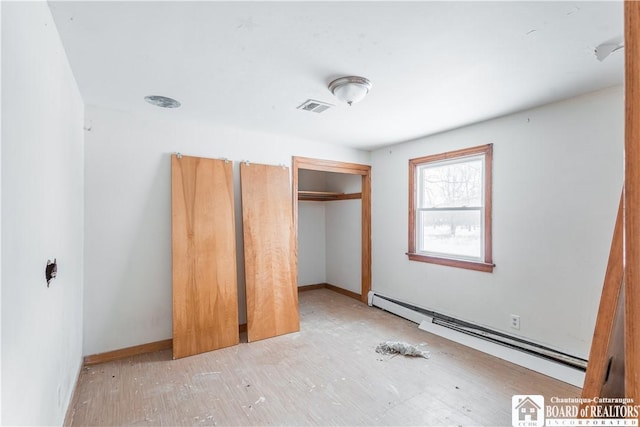 unfurnished bedroom with a baseboard radiator and a closet