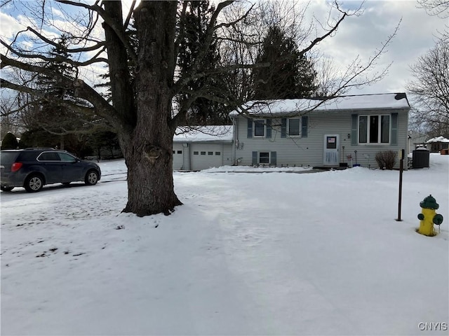 view of front of home with central AC unit and a garage