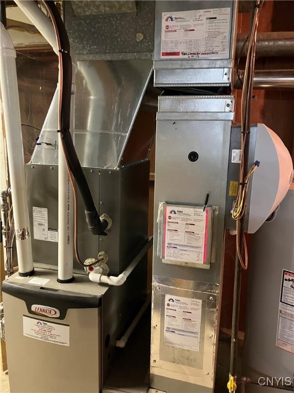 utility room featuring heating unit and gas water heater