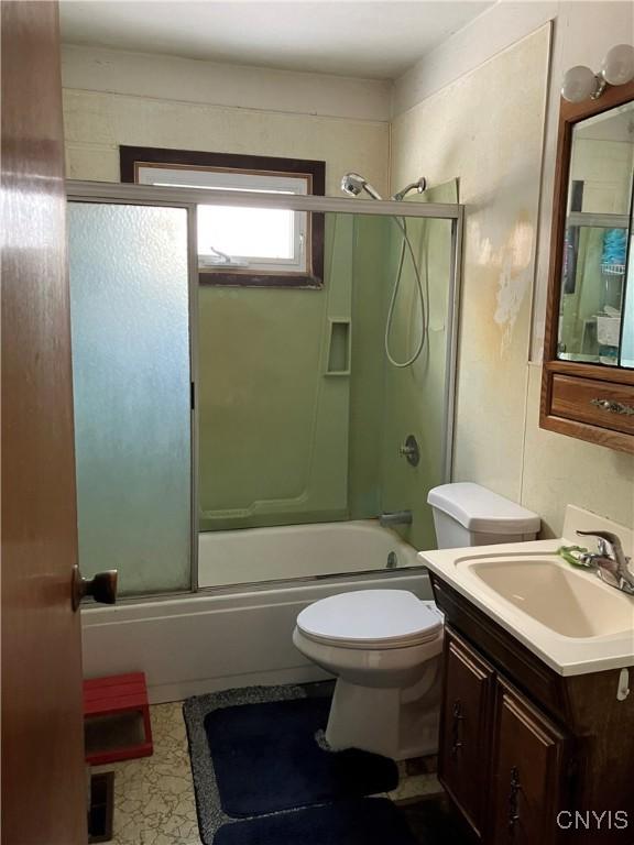 full bathroom with vanity, shower / bath combination with glass door, and toilet