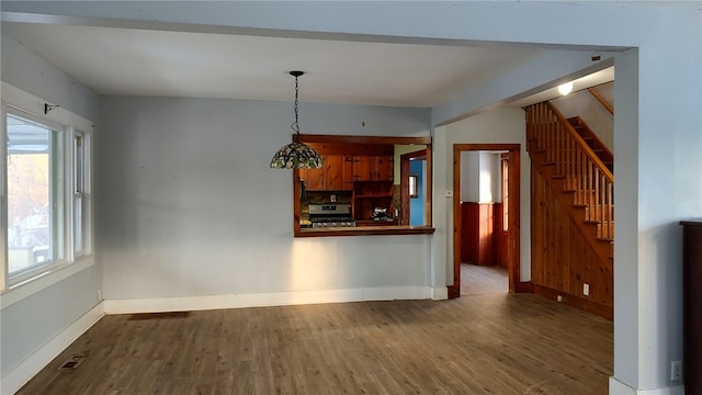 interior space featuring hardwood / wood-style flooring, stainless steel range, and decorative light fixtures