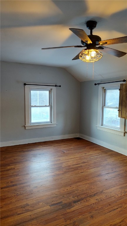 empty room featuring vaulted ceiling, ceiling fan, and dark hardwood / wood-style flooring