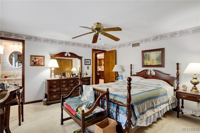 carpeted bedroom with ceiling fan and ensuite bath