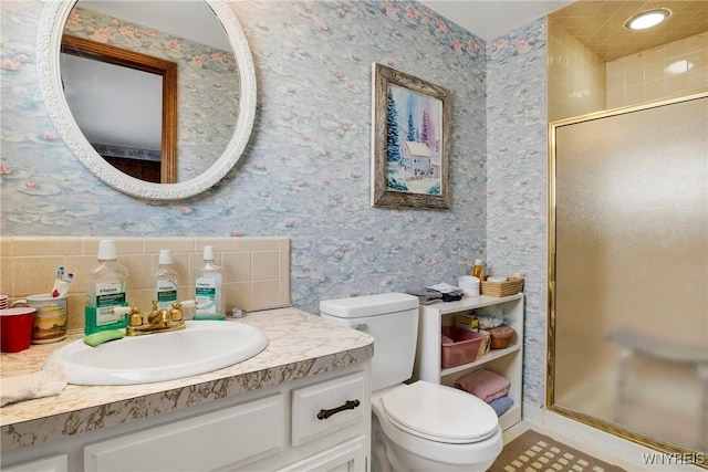 bathroom featuring vanity, a shower with door, and toilet