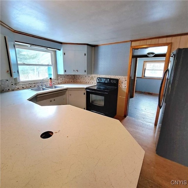 kitchen featuring crown molding, sink, backsplash, and black appliances