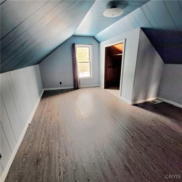 additional living space featuring wood-type flooring and vaulted ceiling