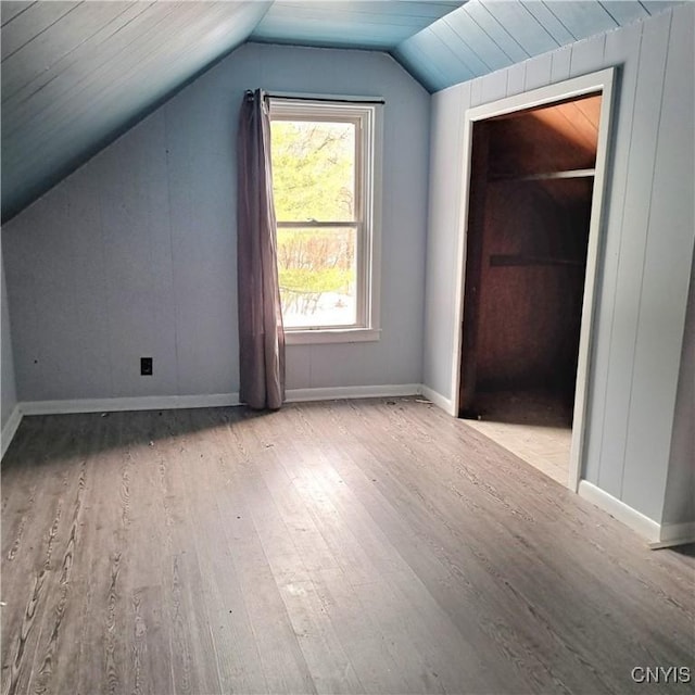 additional living space featuring lofted ceiling and light wood-type flooring