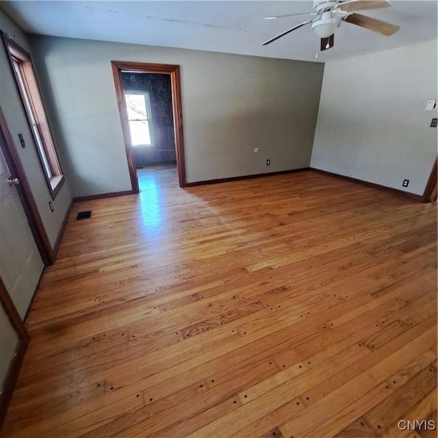 empty room with ceiling fan and light hardwood / wood-style floors