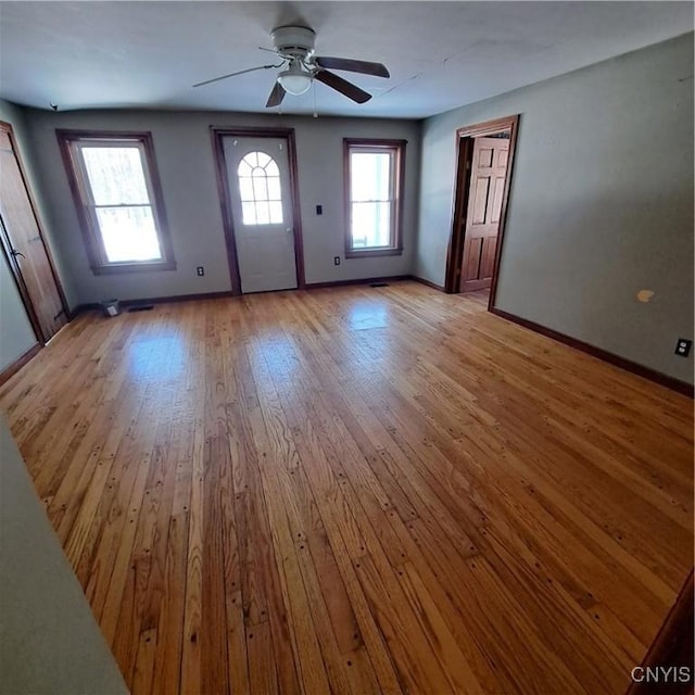 foyer entrance with ceiling fan and light wood-type flooring