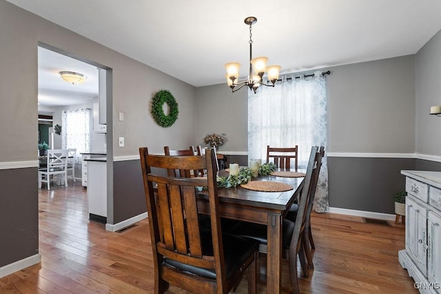 dining area featuring hardwood / wood-style floors and a chandelier