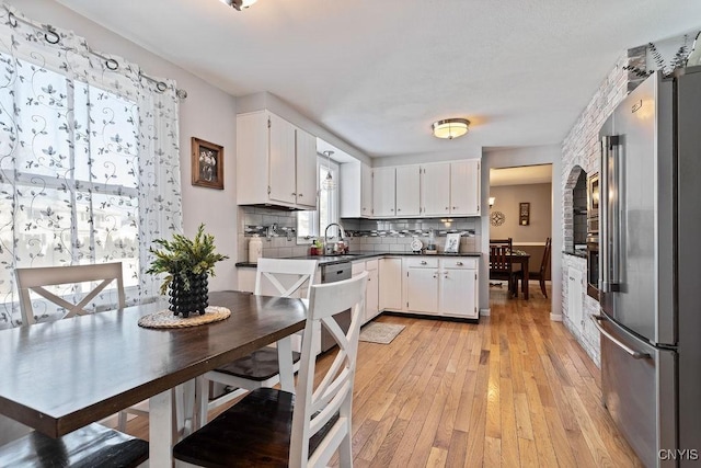 kitchen with white cabinetry, high end fridge, sink, and decorative backsplash