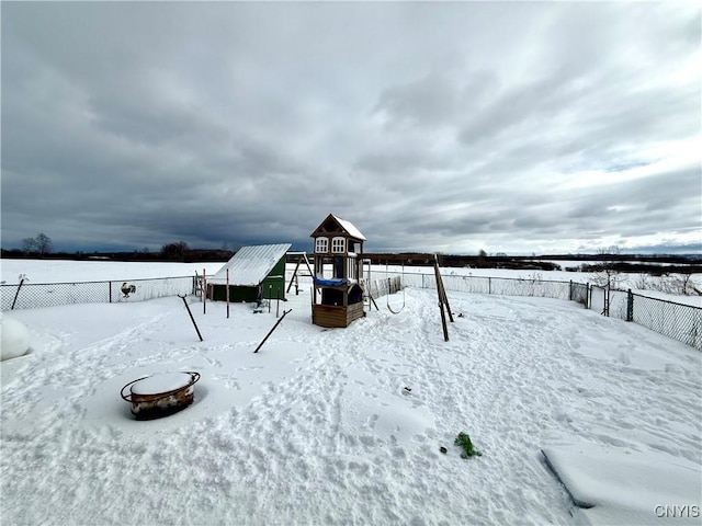 snowy yard featuring a playground