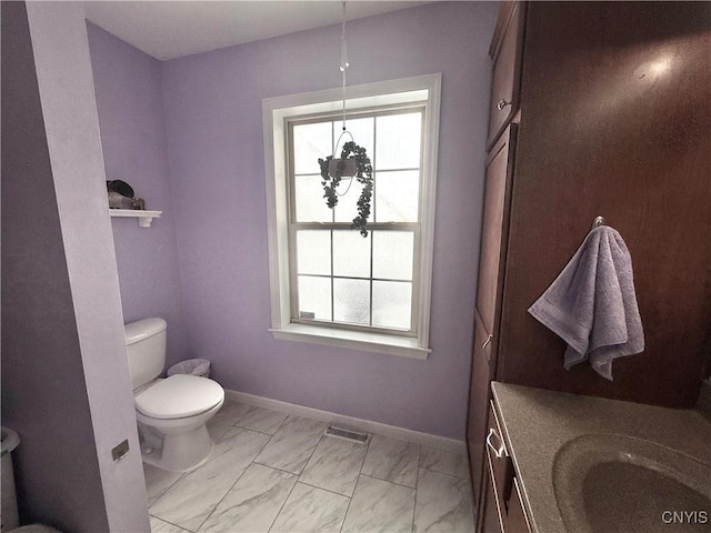 bathroom with vanity, a wealth of natural light, and toilet