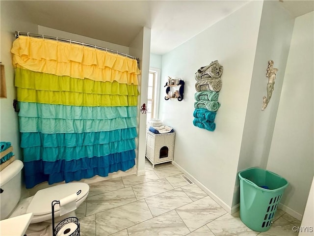 bathroom featuring curtained shower and toilet