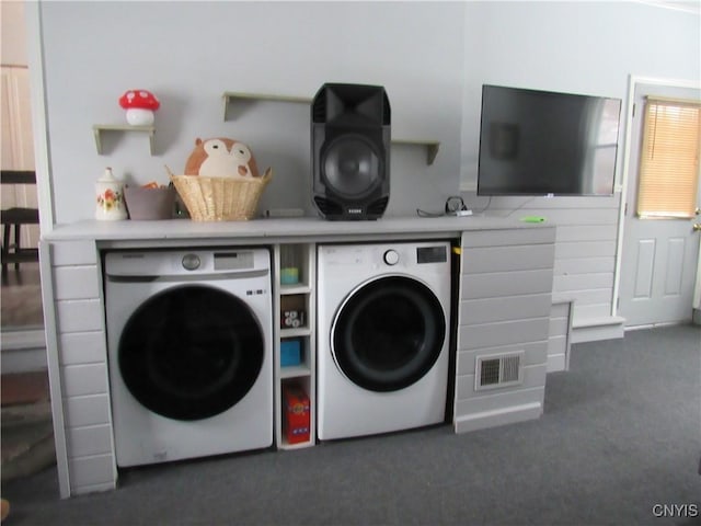 laundry area with washer and clothes dryer and dark colored carpet