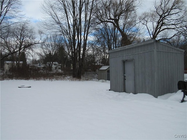 yard layered in snow with a storage unit