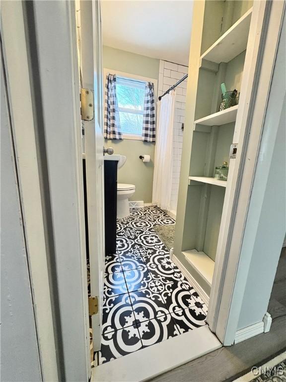 bathroom with tile patterned floors, toilet, and a shower with shower curtain