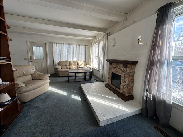 carpeted living room with a fireplace and beamed ceiling