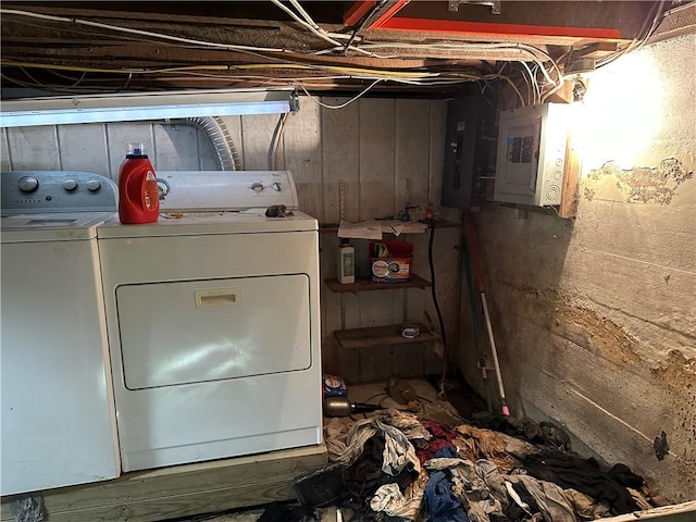 laundry area featuring independent washer and dryer, electric panel, and wooden walls