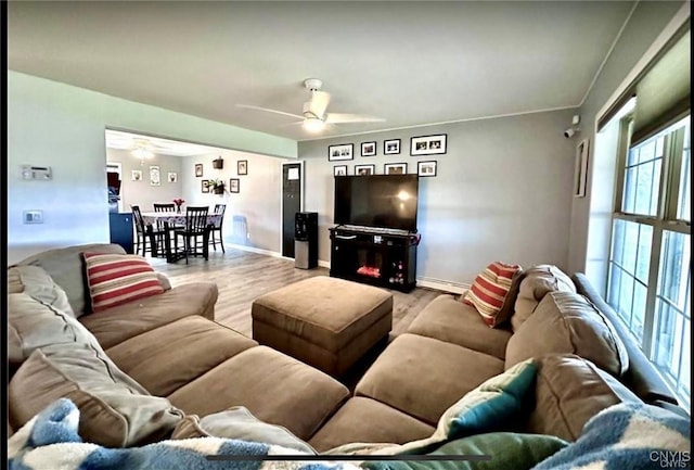 living room with ceiling fan, a baseboard radiator, and light hardwood / wood-style flooring