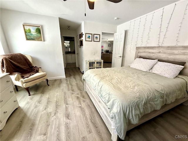 bedroom featuring ceiling fan, light hardwood / wood-style floors, and ensuite bath