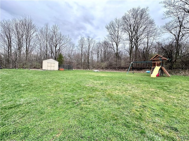 view of yard with a storage shed and a playground