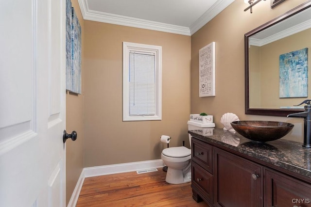 bathroom featuring hardwood / wood-style flooring, vanity, toilet, and crown molding