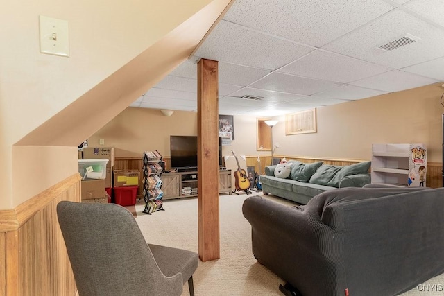 living room featuring carpet flooring and a drop ceiling