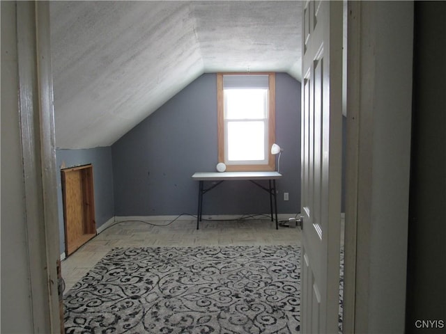 additional living space with vaulted ceiling and a textured ceiling