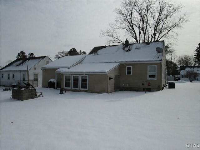 view of snow covered rear of property