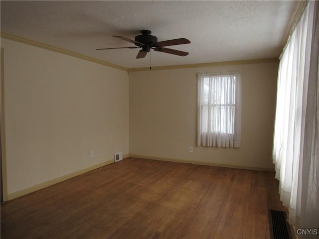 empty room featuring ornamental molding, dark hardwood / wood-style floors, and a textured ceiling