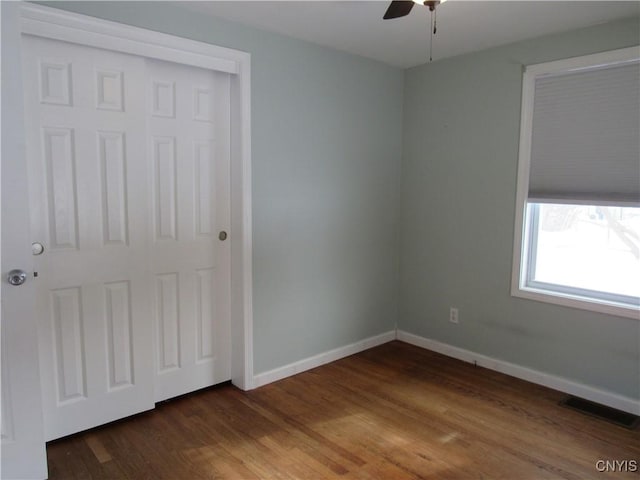 unfurnished bedroom featuring ceiling fan and dark hardwood / wood-style flooring