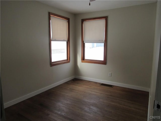 empty room featuring dark wood-type flooring and ceiling fan