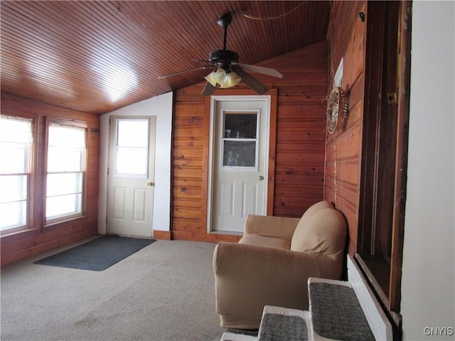 interior space featuring lofted ceiling, wood ceiling, ceiling fan, and wood walls