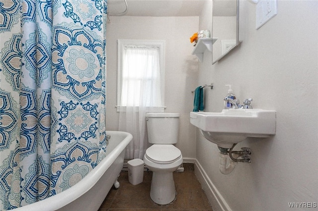 bathroom featuring tile patterned floors, toilet, and a bath